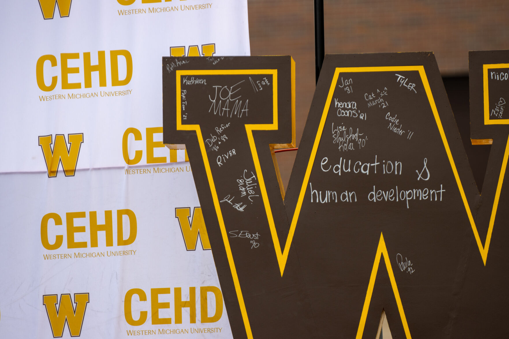 Graduates signed a 'w' outside Floyd Hall.